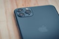 iPhone 11 pro max smart mobile device on a wooden table backside close up photograph. Dark