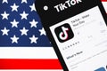 IPhone with TikTok app logo on the screen with USA flag Royalty Free Stock Photo