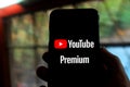 Iphone with the YOUTUBE PREMIUM logo. YouTube Premium is a paid streaming subscription service for YouTube