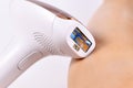 IPL `Intense Pulsed Light` laser hair removal home device next to bare leg Royalty Free Stock Photo