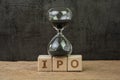 IPO, Initial Public Offering for company to buy and sell in stock market, sandglass or hourglass on wooden cube block with