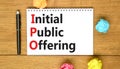 IPO initial public offering symbol. Concept words IPO initial public offering on beautiful white note. Beautiful wooden table