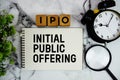 IPO Initial Public Offering text with alarm clock and magnifying glass on marble background Royalty Free Stock Photo