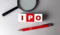 IPO word on wooden cubes with pen and magnifier Royalty Free Stock Photo