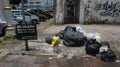 Ignoring signboard warning. Plastic beg and garbage on roadside.