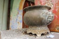 A vintage pot with dragon carvings at a roadside Buddhist shrine in the rustic heritage