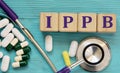 IPPB - acronym on wooden cubes on a blue background with a stethoscope and tablets