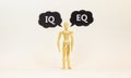 IQ or EQ symbol. Wooden model of businessman human. Black paper. Words IQ, intelligence quotient EQ, emotional quotient. Beautiful Royalty Free Stock Photo