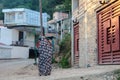 Mazandaran, Iran - 19 July 2017: Iranian woman with traditional colourful burka in a rural area of Iran walking in the village