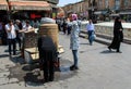 Tabriz, Iran - 10 July 2017: Iranian women with scarf and burka drinking water in the street in a traditional fountain