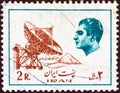 IRAN - CIRCA 1975: A stamp printed in Iran shows Mohammad Reza Pahlavi and an earth telecommunication station