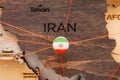 Iran flag on the pushpin and red threads on the wooden map