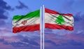 Iran and Lebanon two flags on flagpoles and blue cloudy sky