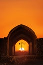 Iran. Yazd. Towers of silence. Traditional architectural arch, a dry lonely tree and a bird at sunset. Copy space.