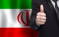 Irani concept. Businessman showing thumb up on the background of flag of Iran Royalty Free Stock Photo