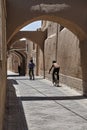 Iranian boys ride bicycles along narrow vaulted alleyway Yazd, I