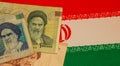 Iranian currency banknotes and the national flag as the background