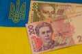 Ukranian currency banknotes and the national flag as the background