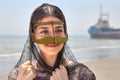Iranian girl in traditional Muslim mask of southern Iran, smiling.