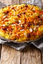 Iranian jeweled rice with dried fruits, carrots, orange zest and nuts closeup on a plate. vertical