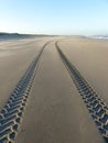 Ire tracks on smooth sandy deserted beach Royalty Free Stock Photo