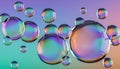 Iridescent bubbles float against gradient backdrop with shimmering rainbow reflections evoking playful sphere motion, fluid light Royalty Free Stock Photo