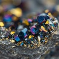 Iridescent crystals with sharp, angular facets displayed on dark, rocky surface. The Royalty Free Stock Photo
