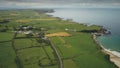 Irish aerial green fields landscape shot: road along meadows. Ireland wide plants and farms