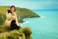 Irish atlantic coast. Woman tourist standing on rock cliff