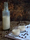 Irish coffee cream liqueur Baileys in glass and botle on wooden background. Royalty Free Stock Photo