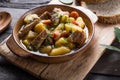 Irish dinner. Beef meat stewed with potatoes, carrots and soda bread on wooden background, top view, copy space. Homemade winter Royalty Free Stock Photo