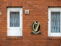 Irish harp emblem and sign Eire on a red brick wall of a building. National symbol of Ireland. Expression of national pride Royalty Free Stock Photo