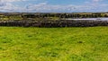 Irish landscape with limestone fences on the island of Inis Oirr with a small beach in the background