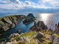 Irish landscape scene with sunlight shining through the clouds above the cliffs and ocean at Malin Head in Ireland