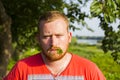 Irish looking read bearded man with clover in his mouth