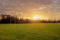 Irish National sport camogie, hurling, football and rugby tall goalposts and training ground at sunset. Selective focus, Sun flare