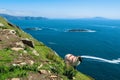 Irish sheep grazing grass on a steep hill. Beautiful landscape scenery with blue sky and ocean in the background. Achill island, Royalty Free Stock Photo