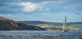 Irish shoreline panorama. Lone sailing yacht.