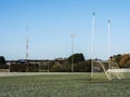 Irish sport training ground with tall goal posts for camogie, Gaelic football and rugby on a cold winter day. Frost on the green