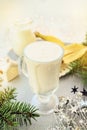 Irish traditional winter cream cocktail eggnog in a glass mug with milk, rum and cinnamon, banana covered with whipped cream, Royalty Free Stock Photo