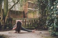 Irish woman yoga teacher training doing a bound side lunge variation skandasana pose in a terrace of a historic garden in