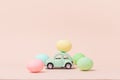 Irkutsk, Russia - january 17, 2021: Light green retro toy car carries easter egg. Happy Easter card in cream colors