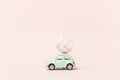 Irkutsk, Russia - january 17, 2021: Light green retro toy car carries easter egg. Minimal easter concept