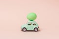 Irkutsk, Russia - january 17, 2021: Light green retro toy car carries easter egg. Minimal easter concept