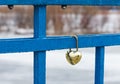 Irkutsk, Russia- 30 March 2021: Closed gold heart shaped padlocks or love lock on blue bridge.
