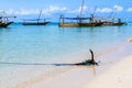 Iron anchor on a sand at beach. Boats at background. Zanzibar, Tanzania Royalty Free Stock Photo