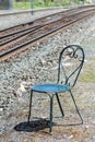 Metal Turquoise Chair with Heart Shaped Back next to Railroad Tracks