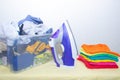 Iron and baby clothes. Colored clothes on an ironing board. Bright t-shirts. Ironed and non-ironed colored children`s underwear o Royalty Free Stock Photo