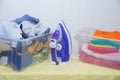 Iron and baby clothes. Colored clothes on an ironing board. Bright t-shirts. Ironed and non-ironed colored children`s underwear o Royalty Free Stock Photo