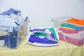 Iron and baby clothes. Colored clothes on an ironing board. Bright t-shirts. Ironed and non-ironed colored children`s underwear o Royalty Free Stock Photo